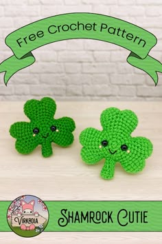 two green crocheted shamrocks sitting next to each other on top of a table