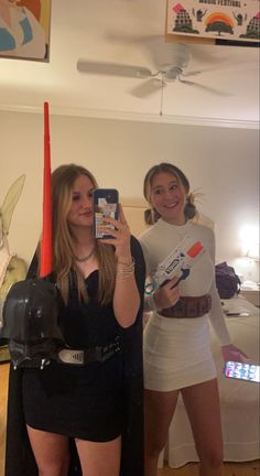 two women dressed up as darth vader and storm trooper taking a selfie