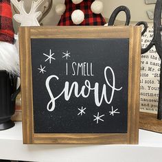 a sign that says i smell snow in front of some christmas decorations and other items