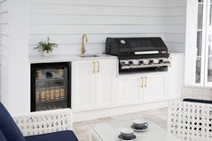 a kitchen with white cabinets and an outdoor grill