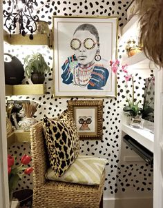 a room with black and white polka dot wallpaper, leopard print chair, framed portrait on the wall