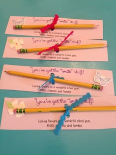 three pencils with writing on them sitting next to each other in front of some pink paper