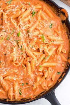 a skillet filled with pasta covered in sauce and parmesan cheese