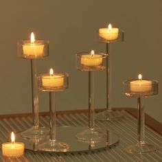 candles are lit in glass holders on a table