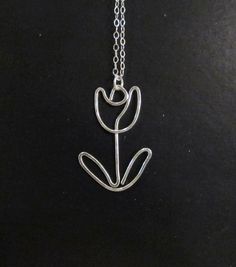 a silver necklace with a flower on it