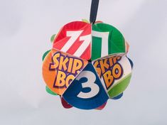 a colorful kite with the number thirteen on it's side hanging in the air