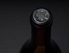 a close up of a bottle of wine on a black surface with a crown emblem