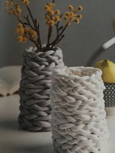 two white vases with yellow flowers in them