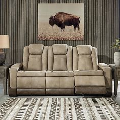 a living room scene with focus on the reclining couch and the animal painting behind it