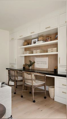 an office with white cabinetry and wooden flooring is pictured in this image, there are two chairs at the desk