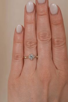 a woman's hand with a diamond ring on it