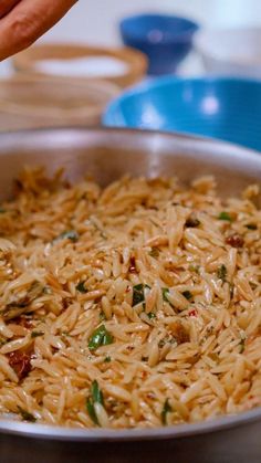 a pan filled with rice and vegetables on top of a table