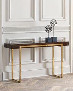 a modern console table in an empty room with white walls and wood flooring on the side