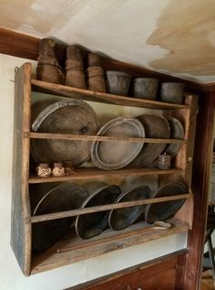 an old wooden shelf filled with pots and pans