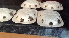 four bundt cakes sitting on top of a counter covered in white frosting and brown sprinkles