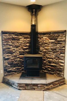 a stone fireplace with a wood burning stove