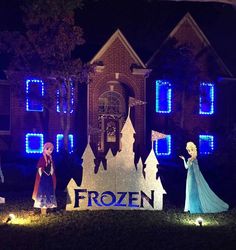 some people are standing in front of a building with lights on it and there is a sign that says frozen