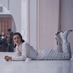 a woman laying on the floor in white clothes