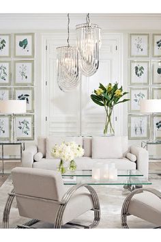 a living room with white furniture and chandelier