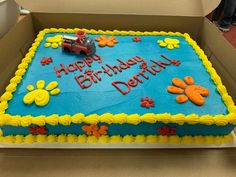 a blue birthday cake with yellow and orange decorations