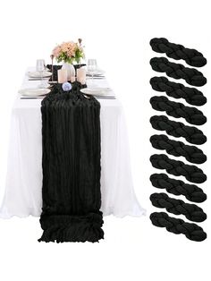 the table is set up with black and white linens, flowers and napkins