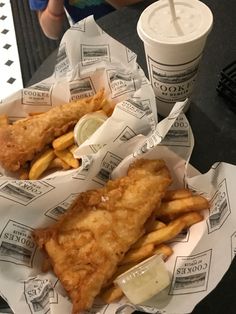 fish and fries in baskets with dipping sauces on the side at a restaurant table