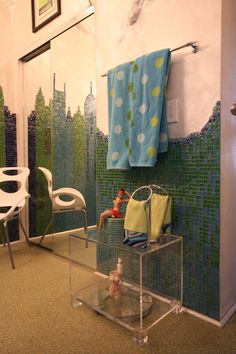 the bathroom is decorated with blue and green tiles, including a towel rack that holds towels