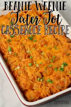 a casserole dish with cheese and green onions in it on a white table