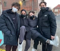 three people wearing masks pose for the camera