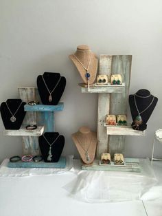 several necklaces are displayed on wooden shelves