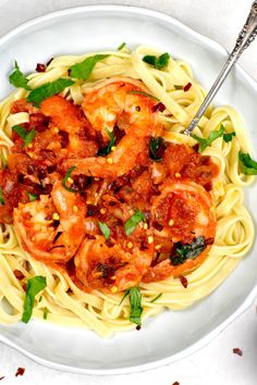 pasta with shrimp and tomato sauce in a white bowl