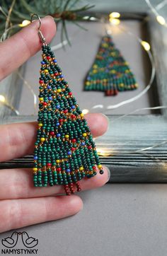 These Christmas tree beaded earrings are made of high-quality Czech beads and metal components. They are elegant, fashionable, and highly versatile, suitable for everyday wear. Features: Sterling silver hooks Color: 2 shades of green, gold, yellow, red, blue, brown Length: 8 cm (3.14 in) This item is currently in stock. More beaded earrings http://etsy.me/2ycItdb Gerdan necklaces http://etsy.me/2mihf0J Beaded necklaces http://etsy.me/2Dkf1Fo Crochet necklaces http://etsy.me/2CAPdFc Back to shop Christmas Bead Necklace, Color Ambar, Bohemian Wedding Earrings, Christmas Tree Beads, Bead Stitch, Fringe Earring, Gold Chandelier Earrings, Beadwork Necklace, Native American Beaded Earrings