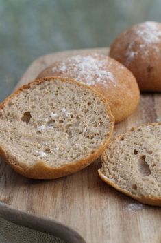 three loaves of bread sitting on top of a wooden cutting board