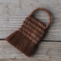 a brown woven bag sitting on top of a wooden table