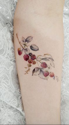 a woman's leg with berries and leaves on it