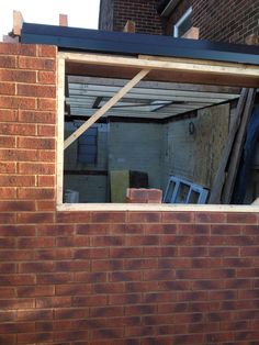 an open window on the side of a brick building that has been torn down and broken