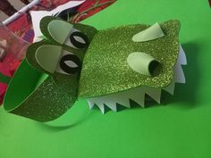 a green paper craft with a monster's head and eyes on top of it