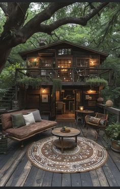 an outdoor living area with couches, chairs and tables in front of a tree