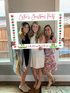 three women holding up a merry christmas sign