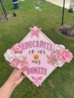 someone holding up a pink graduation cap that says, educadita te ves mus bonita