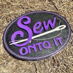 there is a sign that says sew onto it on the ground with straw behind it