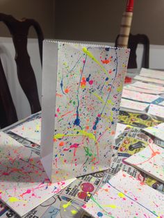 a table topped with lots of cards covered in paint