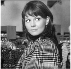 a black and white photo of a woman in a coat