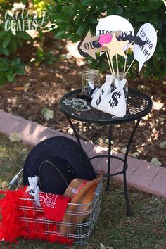 a small table topped with lots of items on top of a grass covered field next to a sidewalk