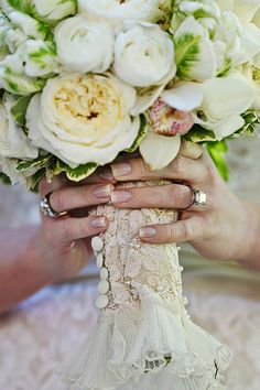 the bride's bouquet is being held by two hands, both holding it together