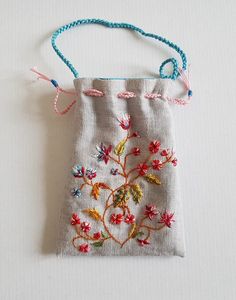 a small bag with embroidered flowers on it