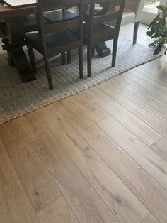 a dining room table with chairs and a rug in front of it on the floor