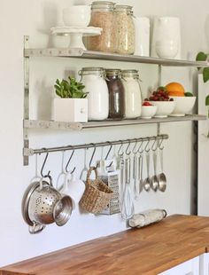 a kitchen counter with pots, pans and utensils hanging on the wall