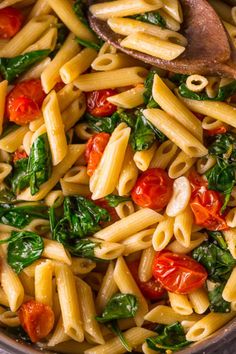 pasta with spinach and tomatoes in a pan