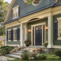 a house with blue shutters and stone steps leading up to the front door area